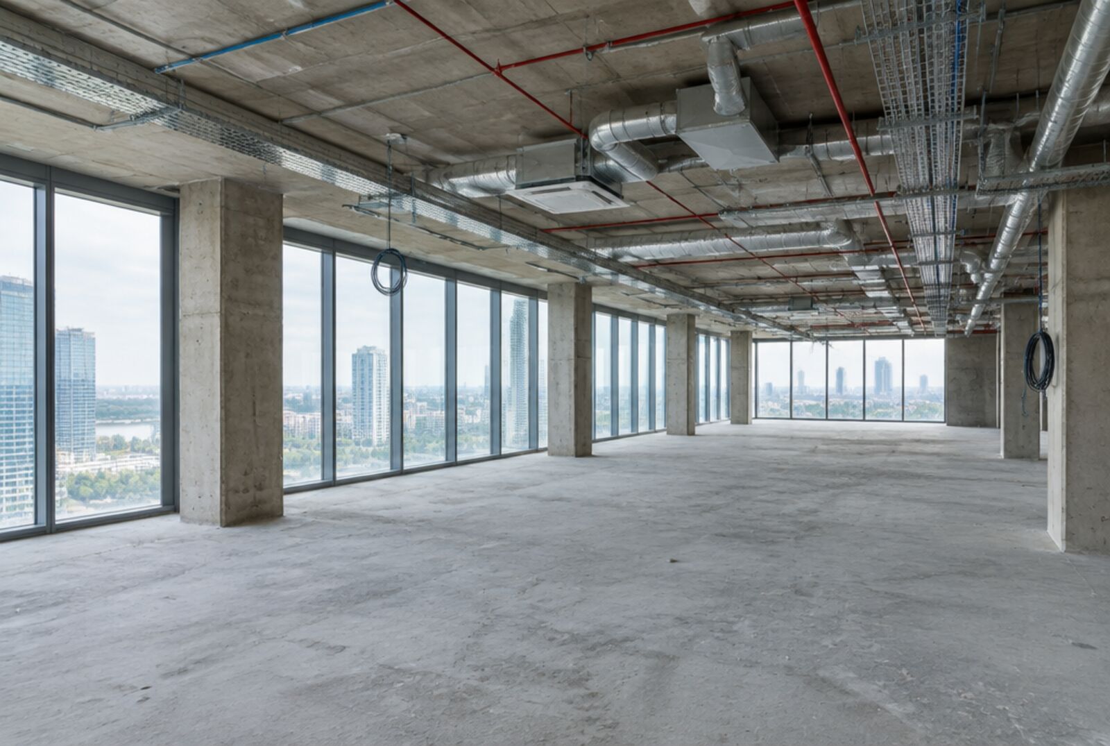 Plateau de bureaux livré en casco : dalle béton brute, sans cloisons ni faux-plafond